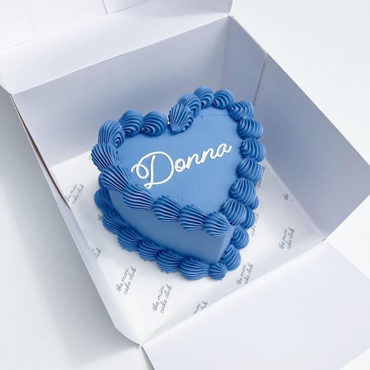 a heart shaped cake in a box with the word donna on it's side