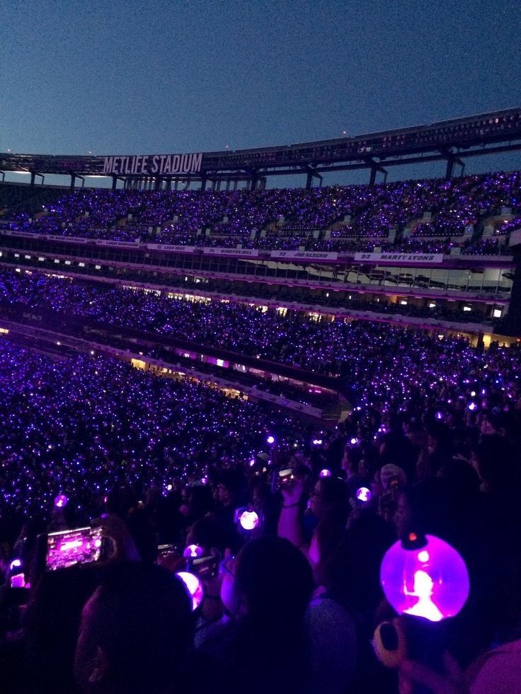 a large stadium filled with lots of people sitting on the bleachers at night