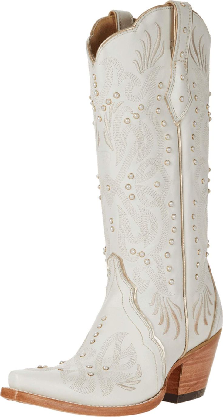 a pair of white cowboy boots with studding on the side and wooden soles