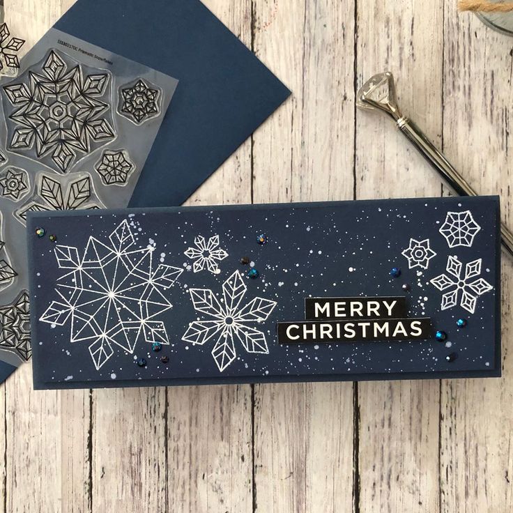 a christmas card sitting on top of a wooden table next to scissors and other crafting supplies