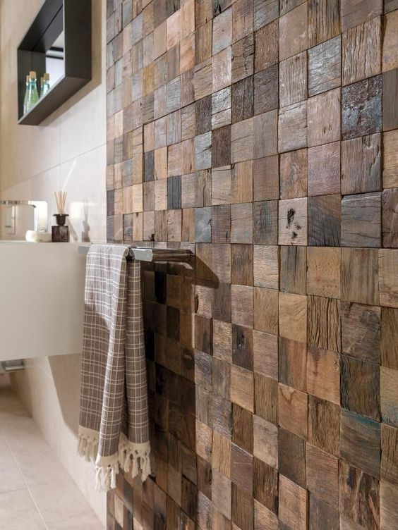 a bathroom with wooden tiles on the wall and towels hanging from it's hooks