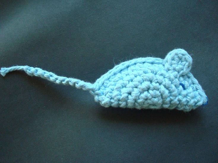 a crocheted blue mouse on a black surface