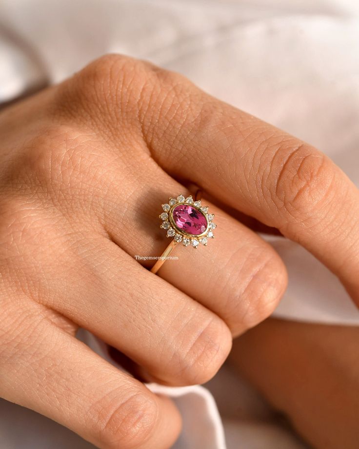 14K Solid Gold Tourmaline Ring,Halo Diamond Ring,Oval Cut Pink Tourmaline Engagement Ring,Anniversary Gift,Pink Promise Ring,Valentines Gift ---------CUSTOM/DUTY-FREE SHIPPING WORLDWIDE, BUYERS DON'T HAVE TO PAY ANY CUSTOM FEES WHILE IMPORTING ------------- Details Made to order Material: 14k/18k gold Color Options: Yellow Gold, White Gold, Rose Gold ★ Center Stone Pink Tourmaline, Oval Size: 5x7 mm Approx Weight (Ct): 0.80 ★ Accent Stones Diamond/CZ Round Size: 1.5 mm * 16 Nos. Approx Weight (Ct): 0.224 ★ Band Width: 1.3 mm ★ 100% Natural Diamond and Gemstones ★ Diamond: Round Brilliant cut, G-H Color, SI Clarity ☂ Shipped with Insured Shipping with 4-7 business days. ➦ 100% Free Returns. ➦ Our Jewelry comes with Lifetime Warranty. (Stone Replacement not included) ✈ We offer free EXPRESS Pink Oval Sapphire Ring With Halo Setting, Gift Pink Ruby Halo Ring, Pink Ruby Ring With Halo For Gift, Pink Ruby Halo Ring Perfect For Gift, Gift Pink Halo Ruby Ring, Pink Ruby Ring With Halo Design, Oval Tourmaline Wedding Rings, Pink Oval Ruby Ring With Halo Design, Pink Oval Gemstone Rings