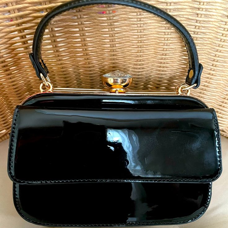 Adorable Black Patent Bag Can Be Hand Carried Or Converted To A Cross Body. The Black Patent And Gold Toned Chain Link Strap Is Removable. This Bag Stands Out With The Diamond Colored Kiss Lock Closure. The Exterior Of The Bag Has A Snap Closure For Cards Etc. The Interior Of The Bag Is Divided Into Two Sections With A Mid Section Zippered Closure. The Metal Closure Details Are In A Gold Tone. Please Note, The Bag Is In Very Good Condition With Minor Unnoticeable Marks And A Few Indented Areas Wherein The Bag Has Touched Another Item. The Bag Is Unused And Comes From A Non Smoking Home. Vintage Satchel Evening Bag For Parties, Vintage Evening Bag With Detachable Handle For Party, Vintage Shoulder Bag With Detachable Handle For Party, Vintage Party Shoulder Bag With Detachable Handle, Classic Black Handheld Clutch, Black Top Handle Shoulder Bag For Party, Classic Black Handheld Evening Bag, Black Clutch With Gold-tone Hardware For Evening, Black Party Clutch With Chain Strap