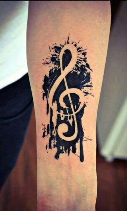 a person with a black and white tattoo on their arm that has music notes painted on it