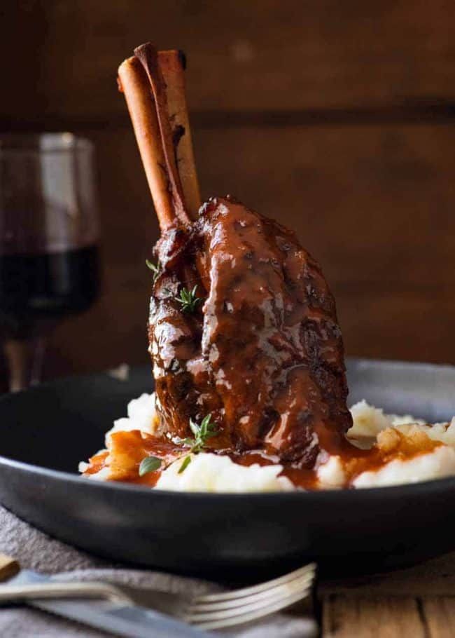 a close up of a plate of food with meat and mashed potatoes