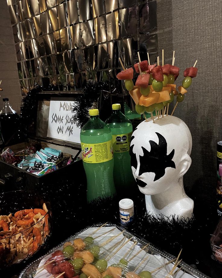 a table topped with lots of food on top of a metal tray next to bottles