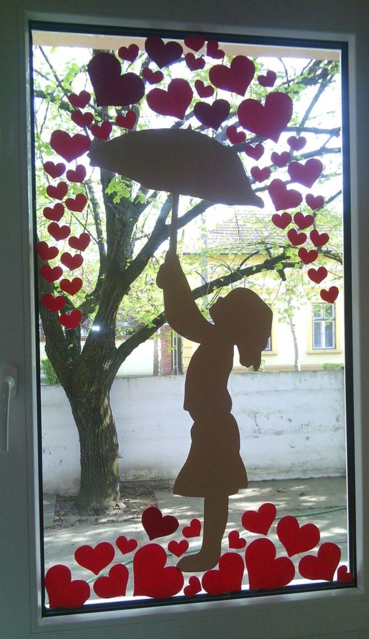 a child holding an umbrella in front of a window with hearts on the windowsill