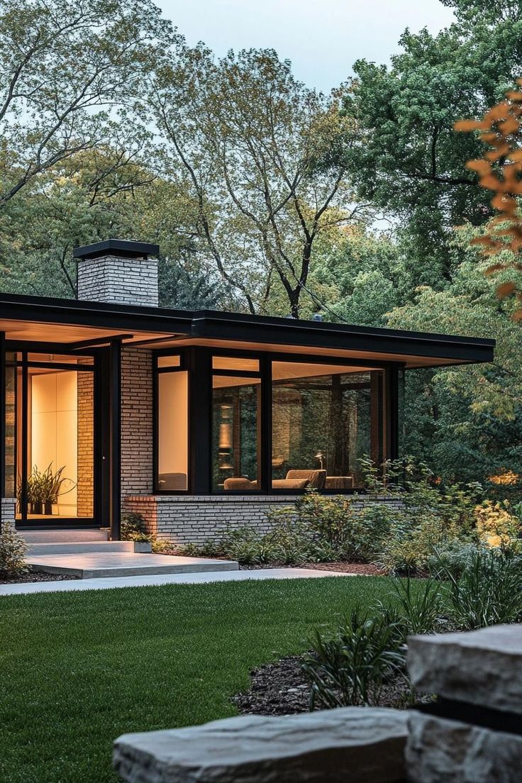 a small modern house surrounded by trees and grass