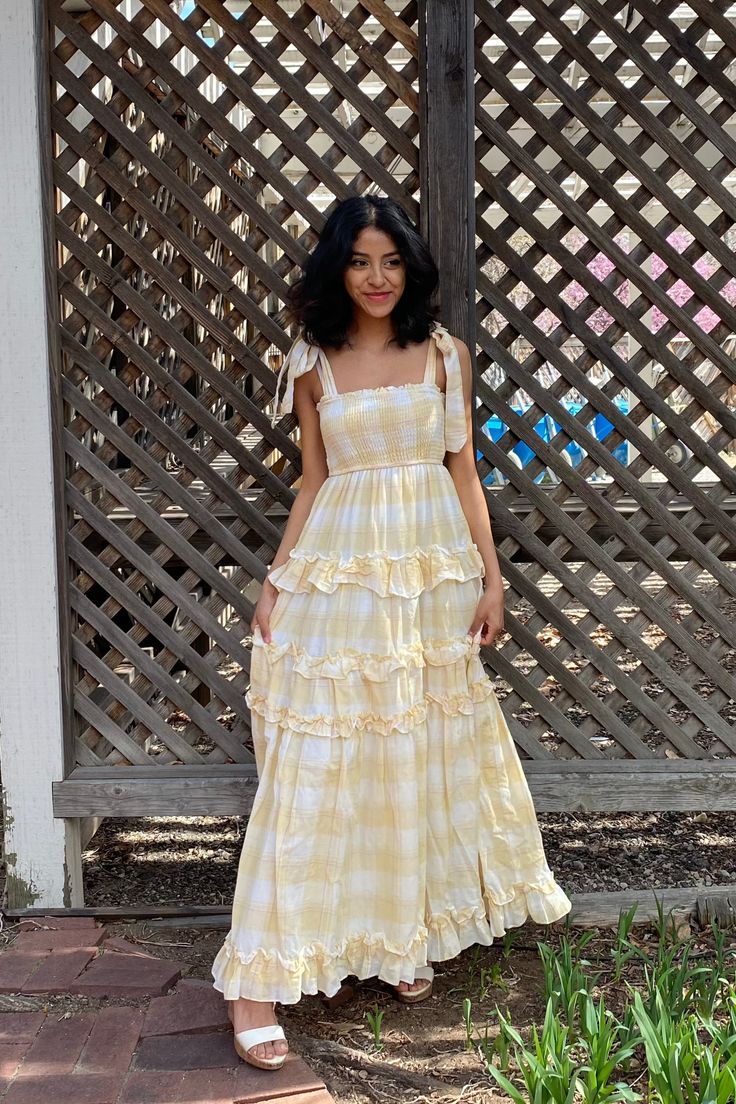 Yellow Plaid Maxi Dress Escape the mundane life and live your cottagecore dreams. Feel the breeze as you twirl and frolic on a prairie field. This dress features a full, ruffled skirt and wide self-tie straps at the shoulders. The lightweight, airy fabric has a plaid pattern of yellow, white and a hint of pink. The upper body is smocked with elastic, which gives a flexible fit. Both the top and skirt of the dress have inner-lining for full coverage and comfort. 100% cotton. Dress is approximatel Mundane Life, La Prairie, Ruffled Skirt, Prairie Dress, Yellow Plaid, Ruffle Skirt, Yellow Dress, Plaid Pattern, Upper Body