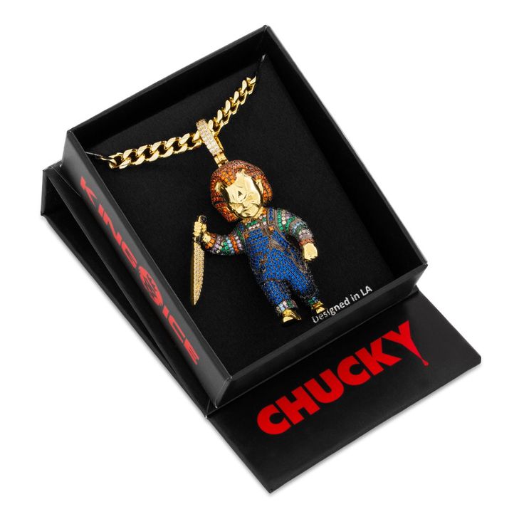 a necklace in a box with a chain attached to it and a figure on the front