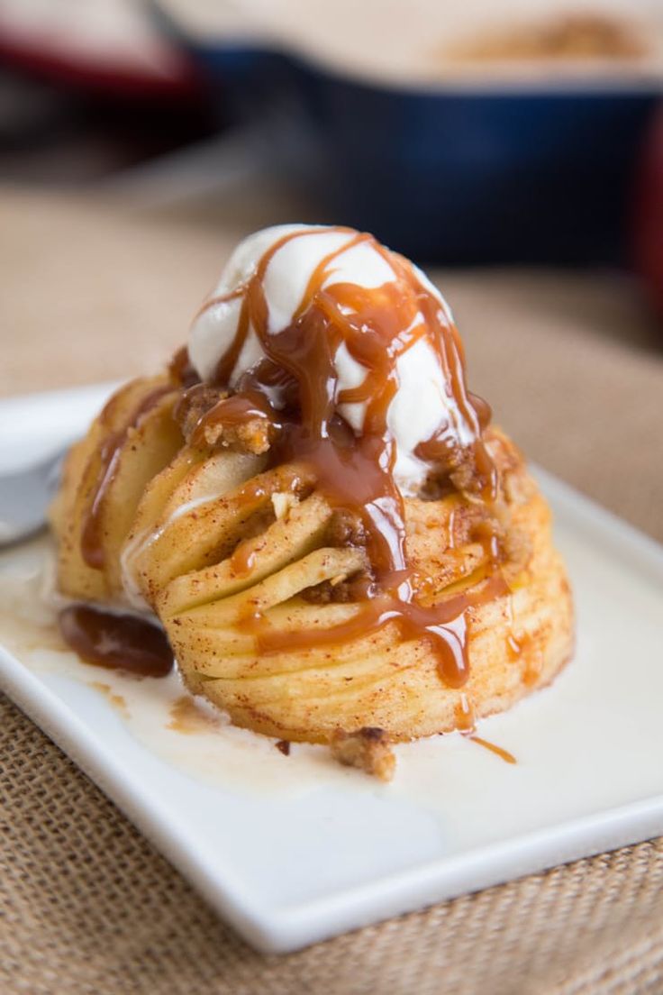 a pastry covered in caramel and drizzled with icing on a white plate