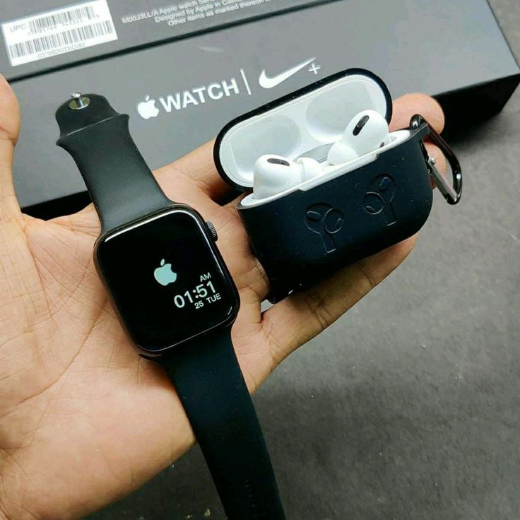 someone holding an apple watch and ear buds in their hand, with the box open