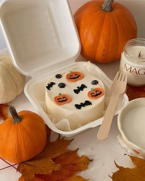 a table with pumpkins, candles and other items for halloween baking on it's surface