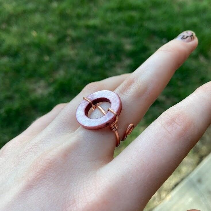 This ring is made to be adjustable! The two ends of the wire on the bottom bend apart to be adjusted!  The circle bead will not move and is glued down.  I love this unique ring and when I made it I knew It needed a unique name! A very good statement ring that could work well with some cute pink or copper rings or other jewelry. Be aware that copper can cause the skin to be green when wet. This is naturally occurring and is a chemical reaction called oxidation.  If you are allergic to certain met Adjustable Rose Gold Wire Wrapped Ring, Adjustable Wire Wrapped Rose Gold Ring, Adjustable Wire Wrapped Midi Rings, Adjustable Wire Wrapped Open Midi Rings, Adjustable Circular Copper Jewelry, Adjustable Nickel-free Copper Ring, Adjustable Copper Nickel-free Rings, Adjustable Circle Wire Wrapped Jewelry, Adjustable Copper Metal Ring Jewelry