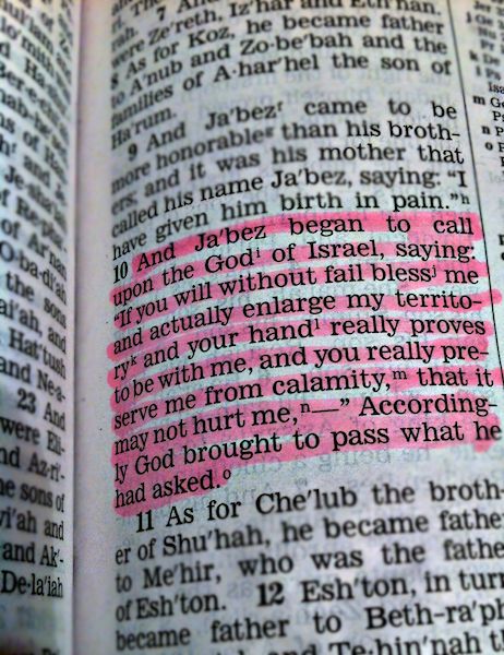 an open bible with the word jesus written in pink on it's page,