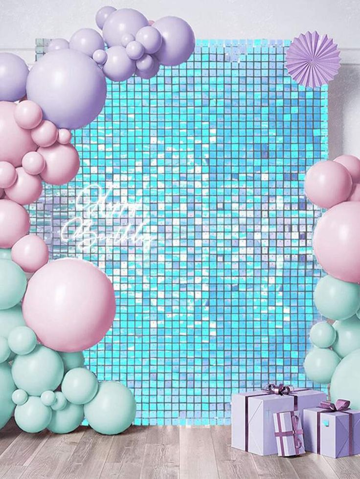 balloons and streamers in front of a blue tiled wall with a gift box on the floor