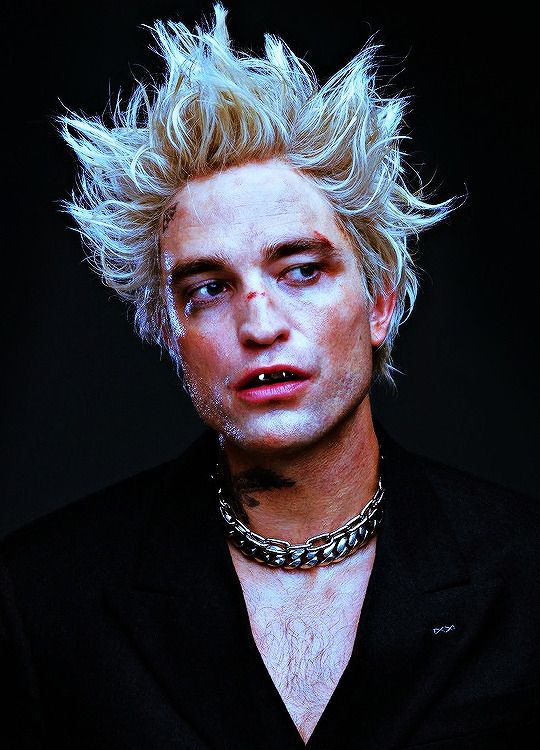 a man with blonde hair and chains on his neck