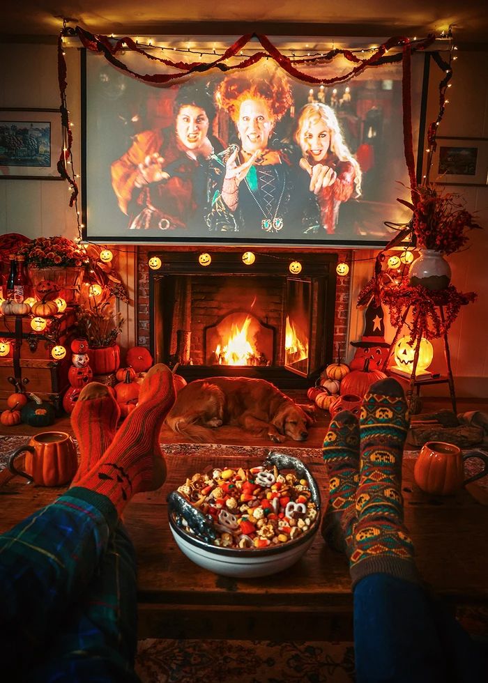 a person with their feet on a table in front of a fire place and television