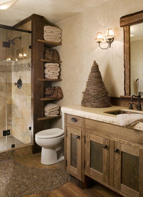 a bathroom with a toilet, shower and shelves filled with folded towels in the corner