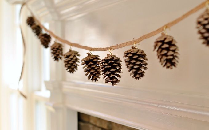 pine cones hanging from a string on a fireplace