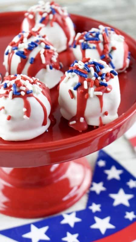 red, white and blue desserts on a red plate with an american flag napkin