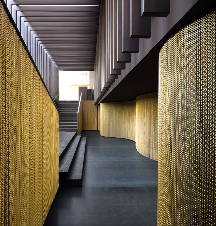 the stairs and railings are lined with gold mesh covering them, along with black concrete flooring