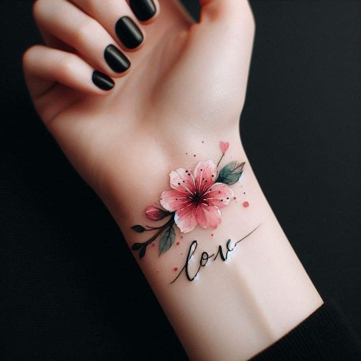 a woman's wrist with a flower on it and the word love written in cursive writing