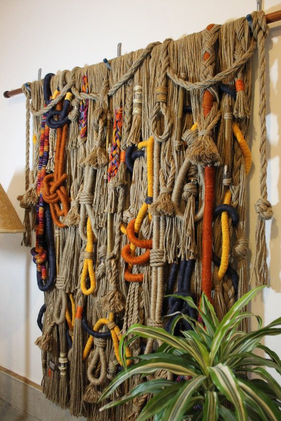 there is a wall hanging made out of rope and various colored ropes on the wall