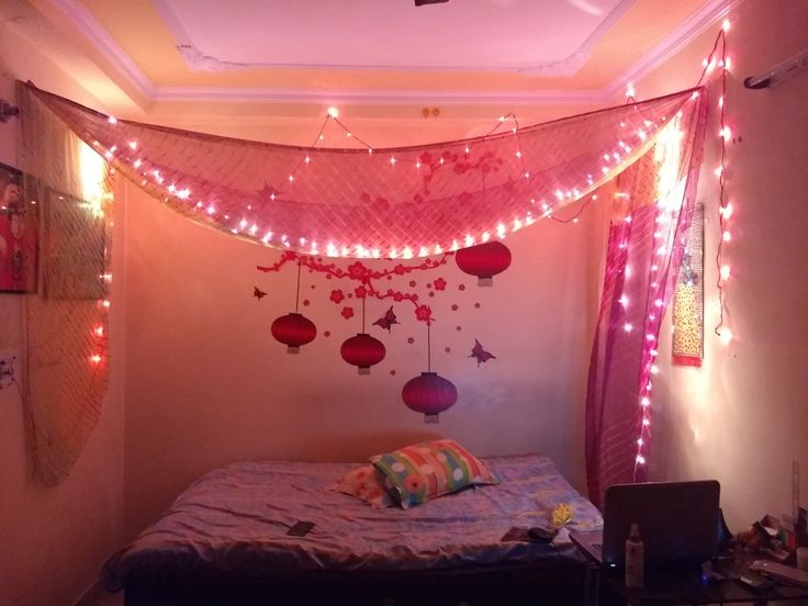 a bed with pink lights hanging from the ceiling