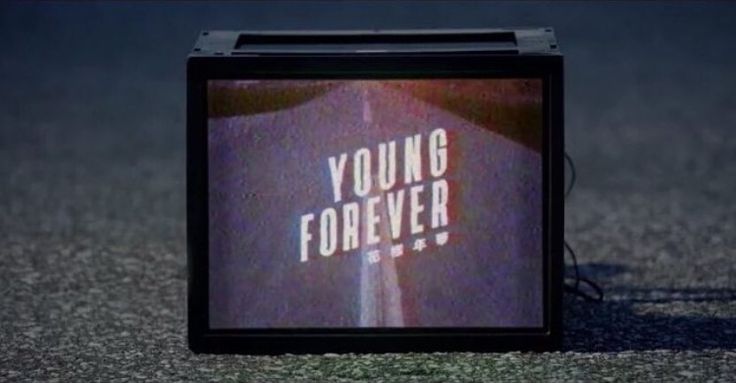 a small television with the words young forever on it's screen in front of an empty parking lot