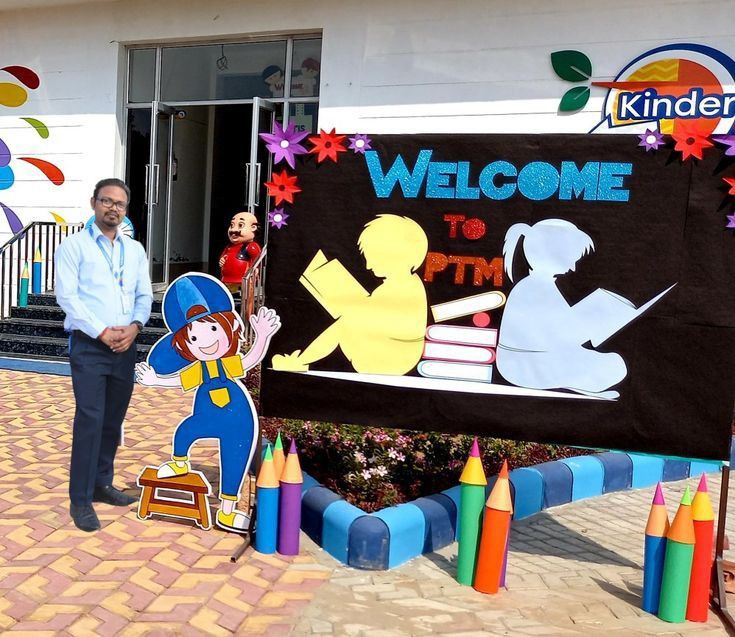 a man standing in front of a welcome sign with crayons on the ground