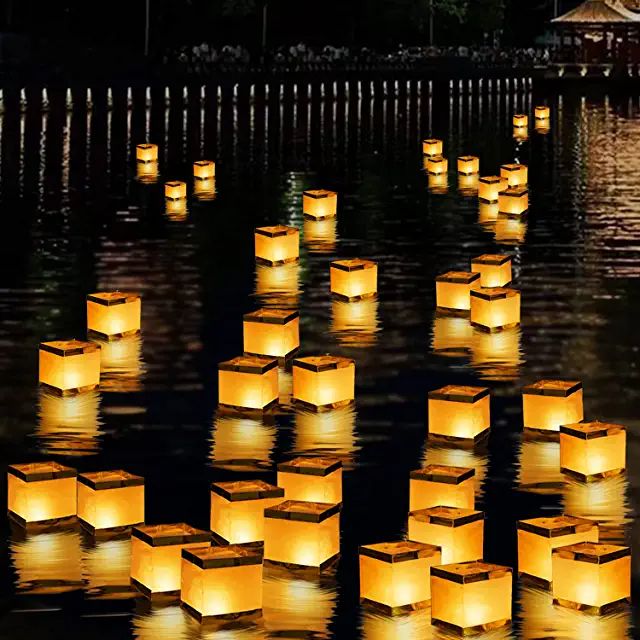 lanterns floating in the water at night