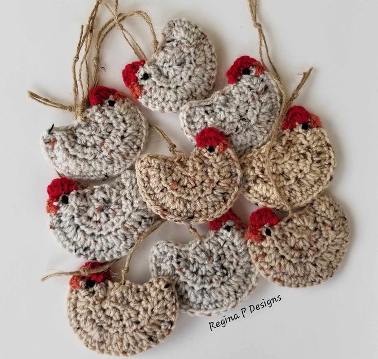 several crocheted chicken ornaments hanging from twine with red and white pomegranates