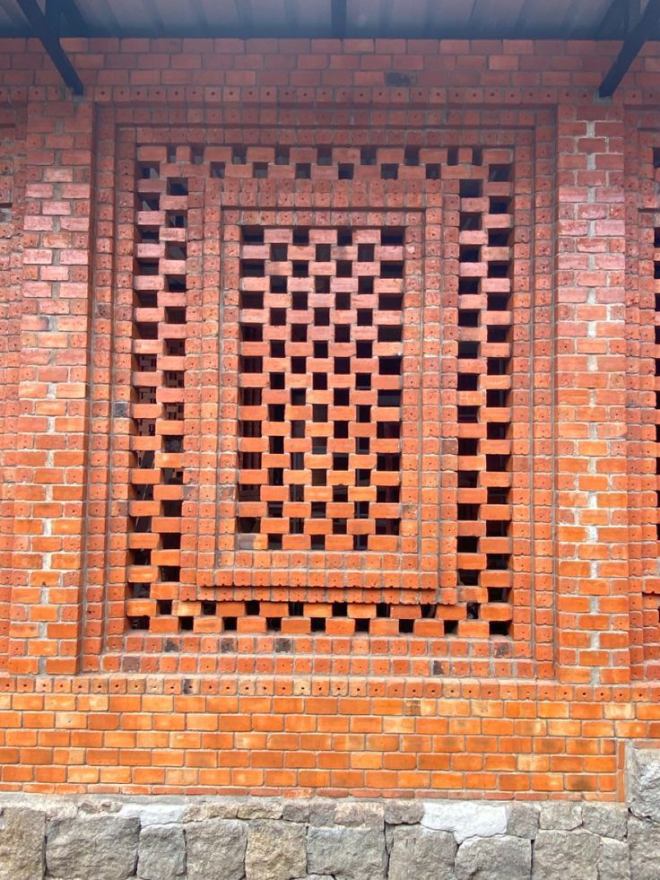 a red brick wall with an open window in the middle