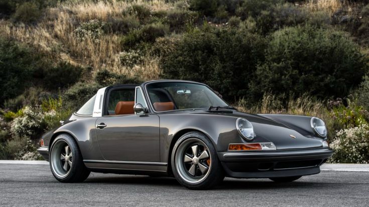 a gray porsche parked on the side of a road