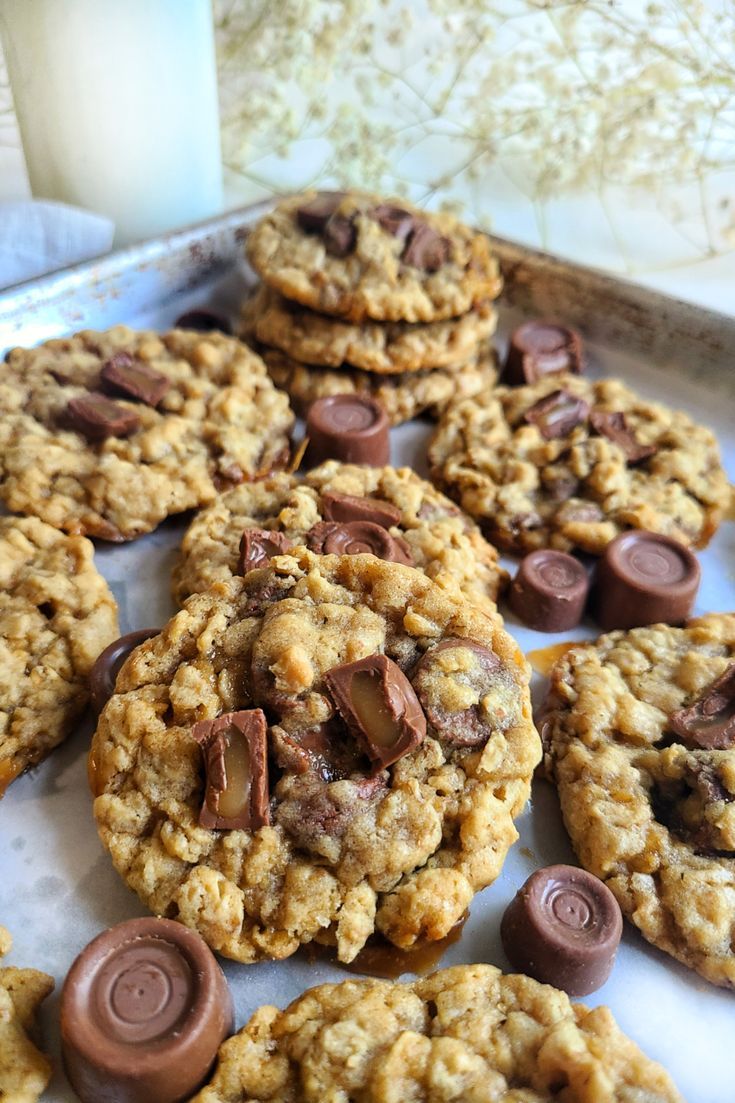 chocolate chip cookies on a baking sheet next to a glass of milk