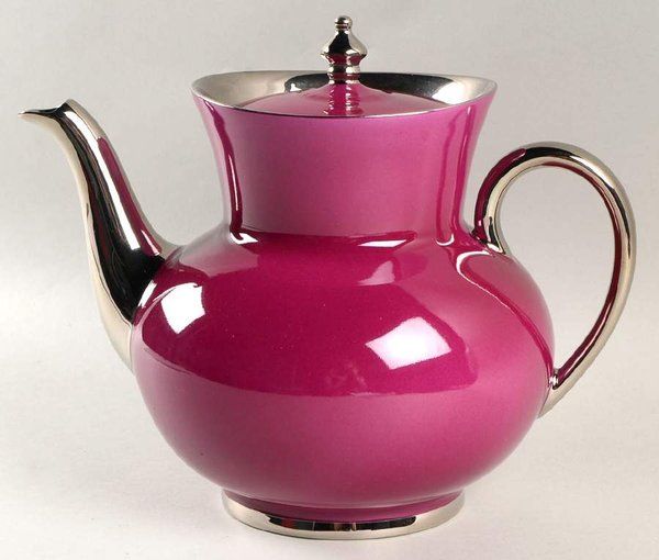 a pink tea pot with a silver lid