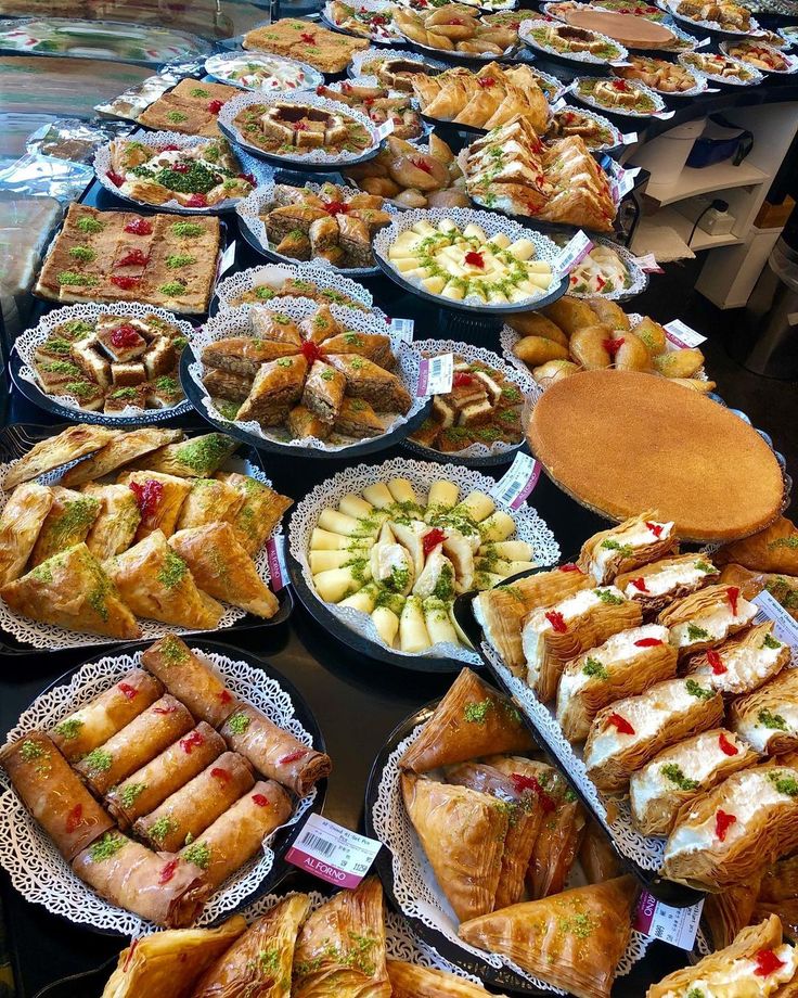 a table filled with lots of different types of sandwiches and desserts on plates next to each other