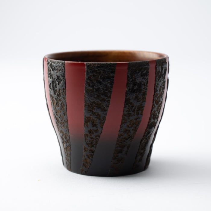 a black and red striped cup sitting on top of a table