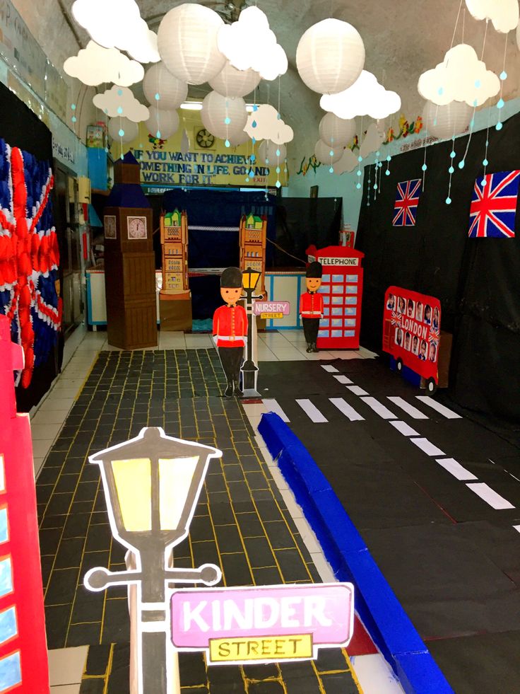 the interior of a children's playroom decorated with british flags and lights hanging from the ceiling