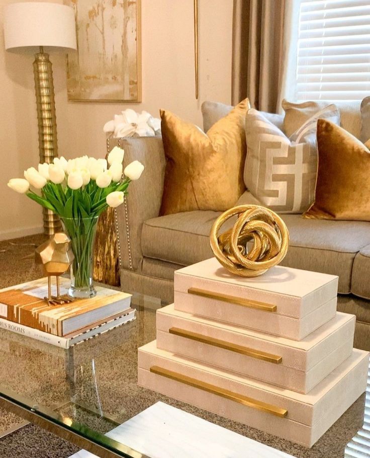 a living room filled with lots of furniture and flowers on top of a glass table