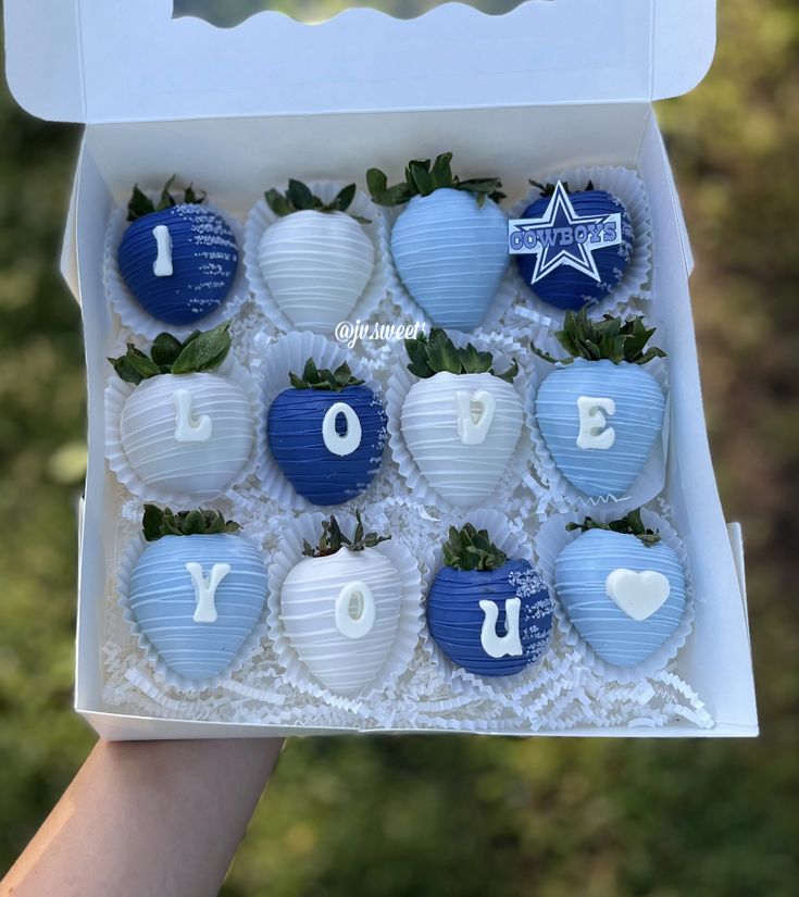 a box filled with blue and white chocolate covered strawberries