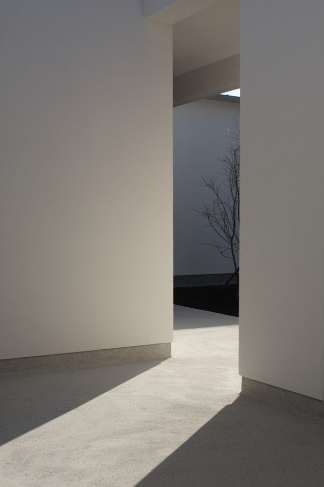 an empty room with white walls and shadows on the floor