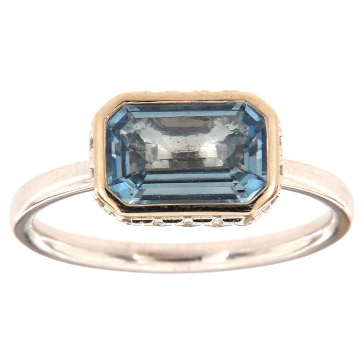 This 14k White gold delicate ring features a 1.23 Carat Blue Aquamarine emerald cut bezel set East-West style. Sixteen (16)Brilliant round diamonds are micro-prong set in a hidden halo on the crown to create the sparkle look every woman is looking to have. The diamond weight is 0.23 Carat, The band is 2 mm wide, and the ring size is 6.5 and resizable per request. Luxury Octagon Ring With Bezel Setting, Elegant White Gold Octagon Topaz Ring, Formal Octagon Emerald Ring With Bezel Setting, Platinum Octagon Ring With Accent Stones, Blue Emerald Cut Ring With Bezel Setting, Platinum Emerald Cut Ring With Bezel Setting, Blue Emerald Cut Rings With Bezel Setting, Yellow Gold Octagon Topaz Ring In Fine Jewelry Style, Yellow Gold Octagon Topaz Ring Fine Jewelry