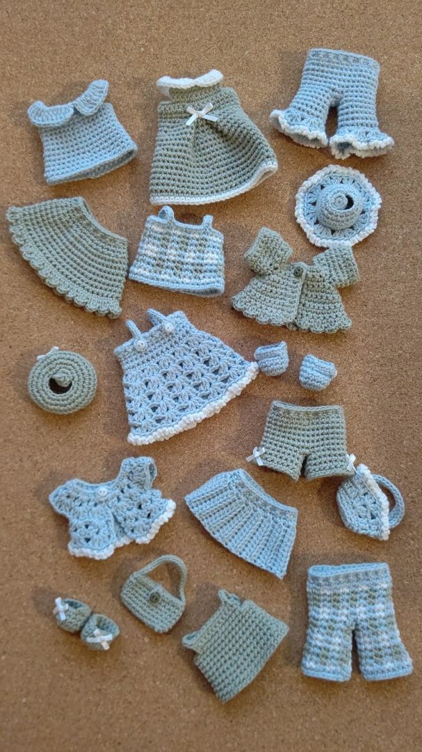 there are many crocheted baby items on the table together, including hats and diapers