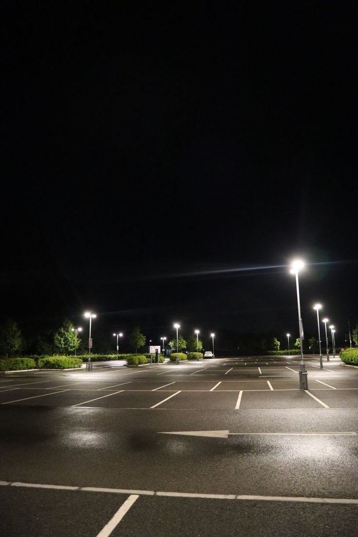 an empty parking lot at night with street lights