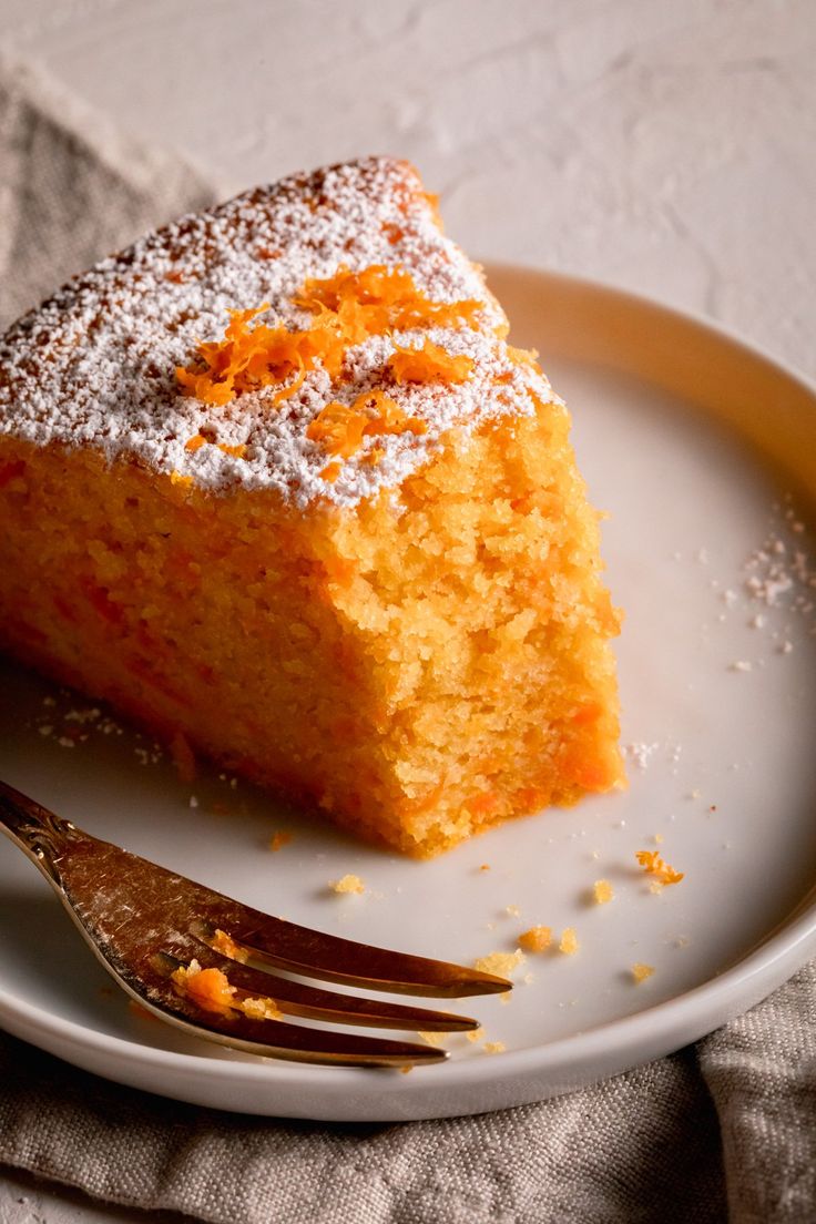 a piece of cake sitting on top of a white plate with a fork next to it