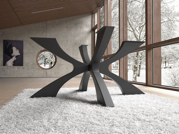 a large metal sculpture sitting on top of a white rug in front of a window