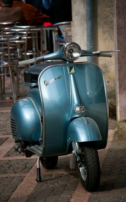 a blue scooter is parked on the sidewalk